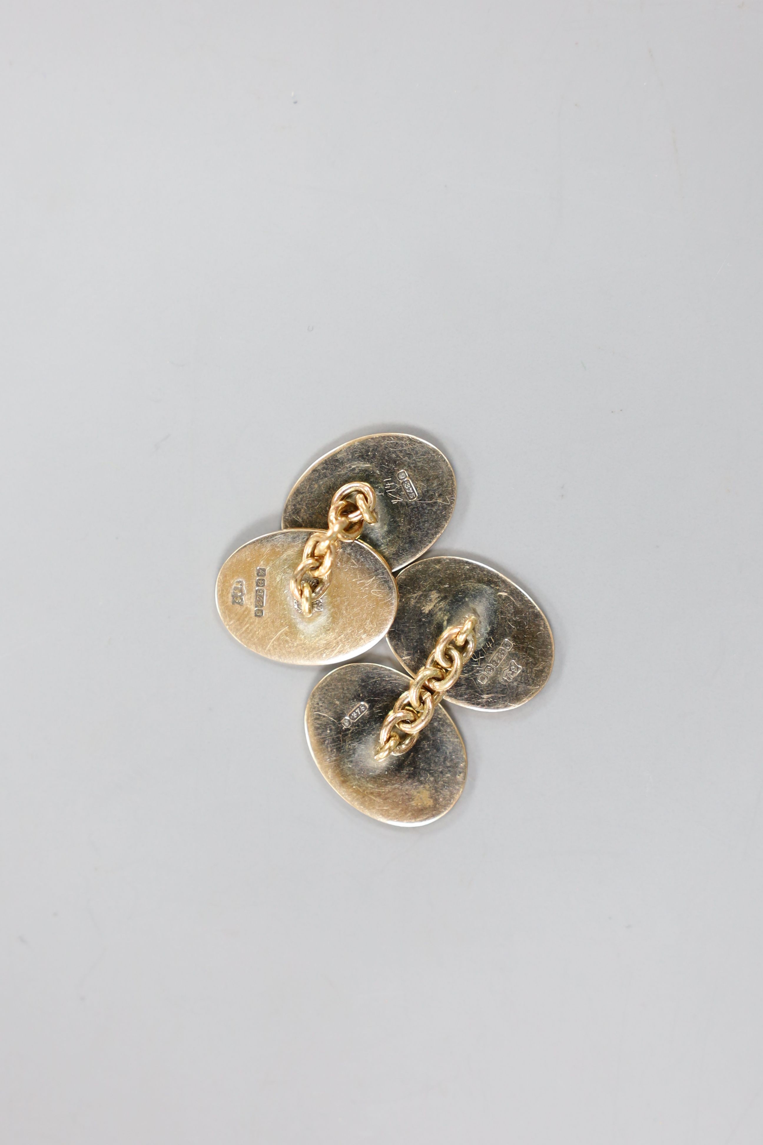 A modern pair of 9ct gold and two colour enamel set oval cufflinks, with Greek key border, 18mm, gross weight 10.5 grams.